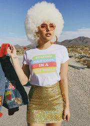 Girl wearing white cotton t-shirt that says Staying Mad Cool in a shit world.